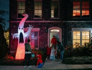 family going trick or treating outside in the dark