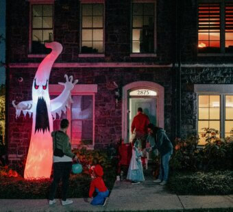 family going trick or treating outside in the dark