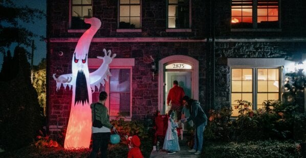 family going trick or treating outside in the dark