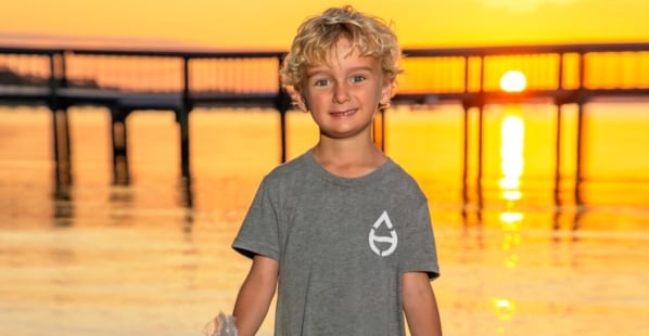 Boy holding trash by the beach