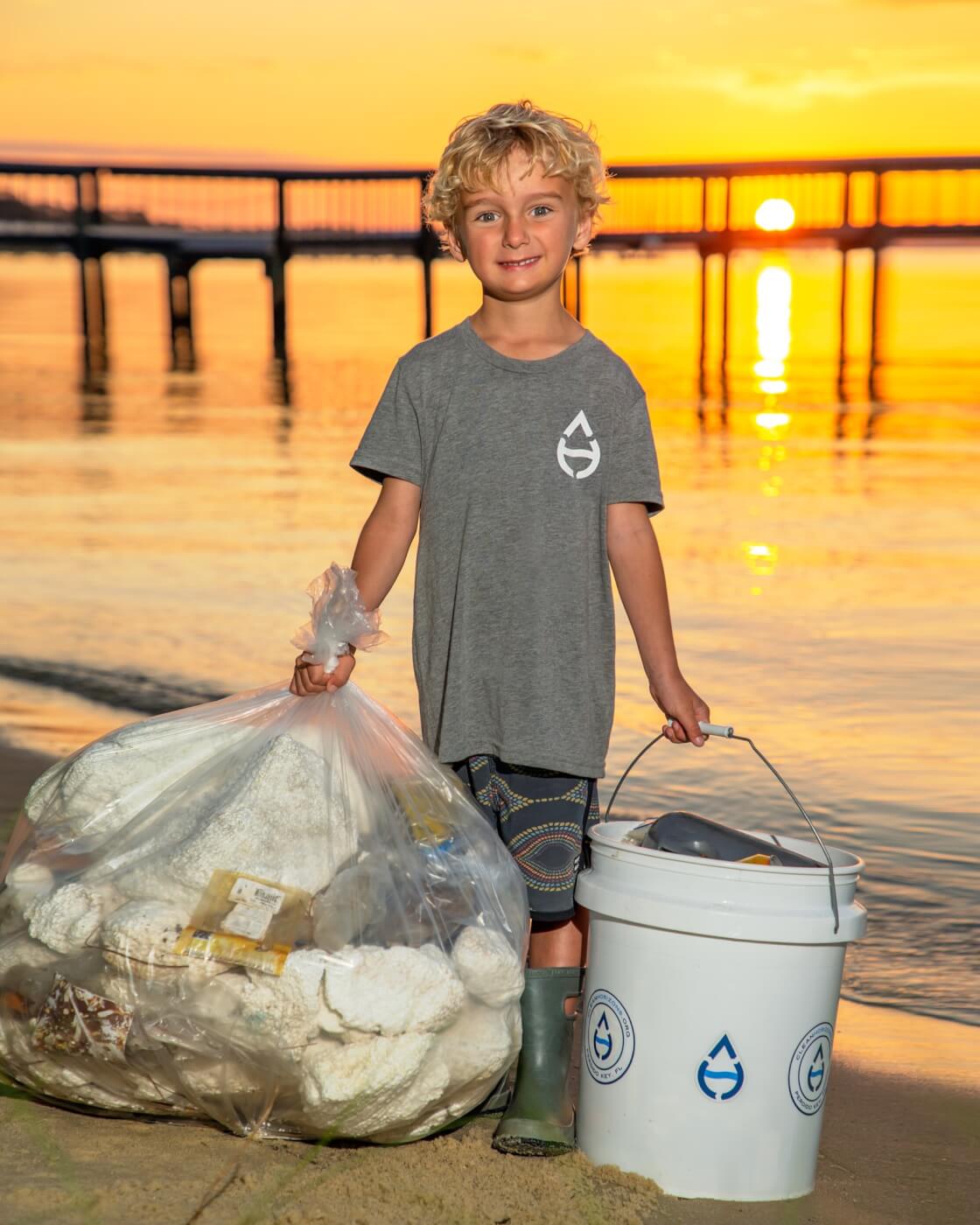 Boy holding trash by the beach
