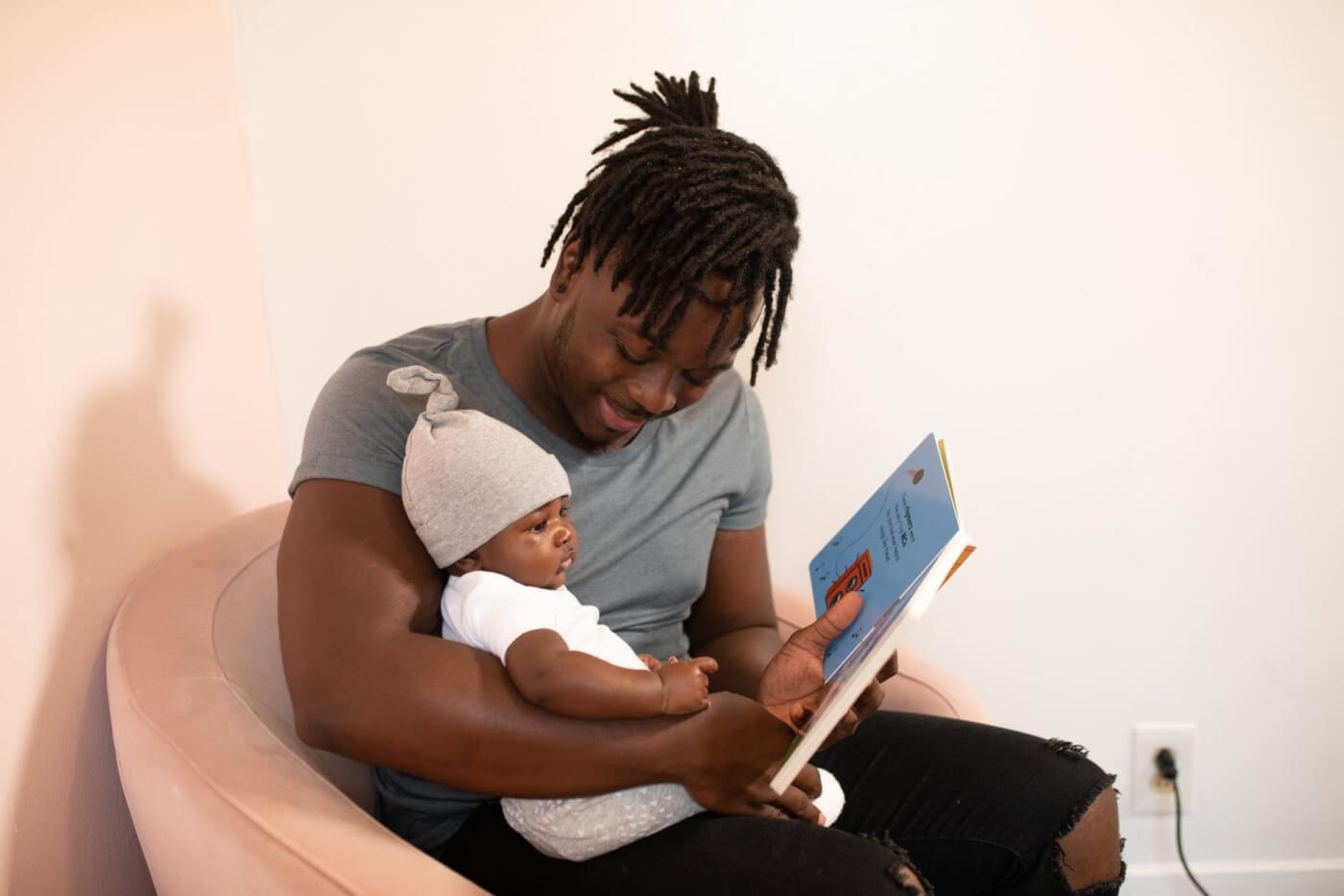 man reading book to baby