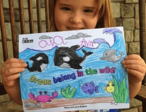 child holding a coloring page