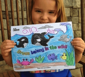 child holding a coloring page