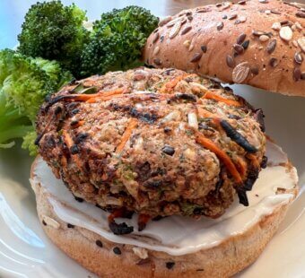 Nora Cooks veggie burger on a bun with a side of broccoli