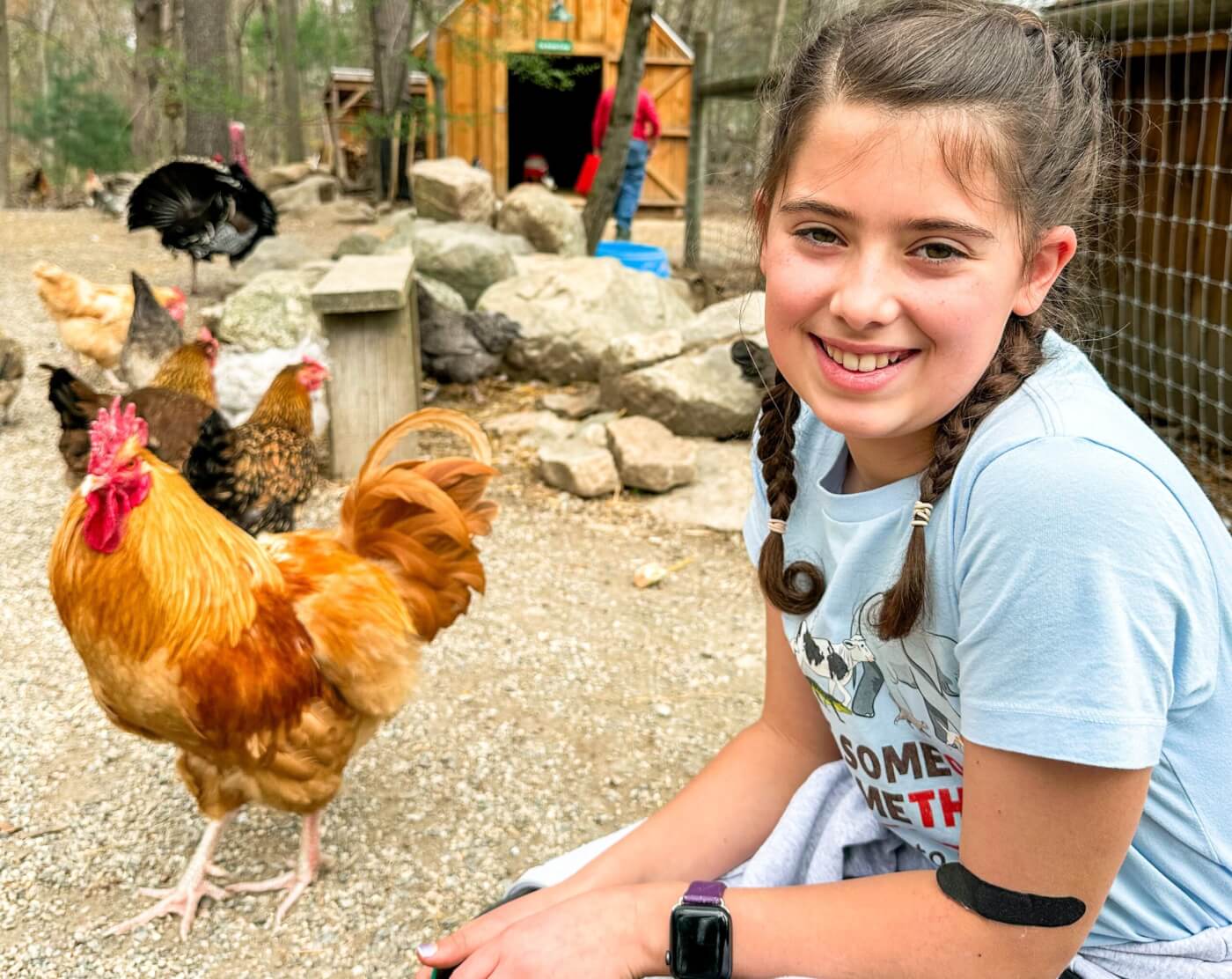 Dani at an animal sanctuary smiling next to a chicken
