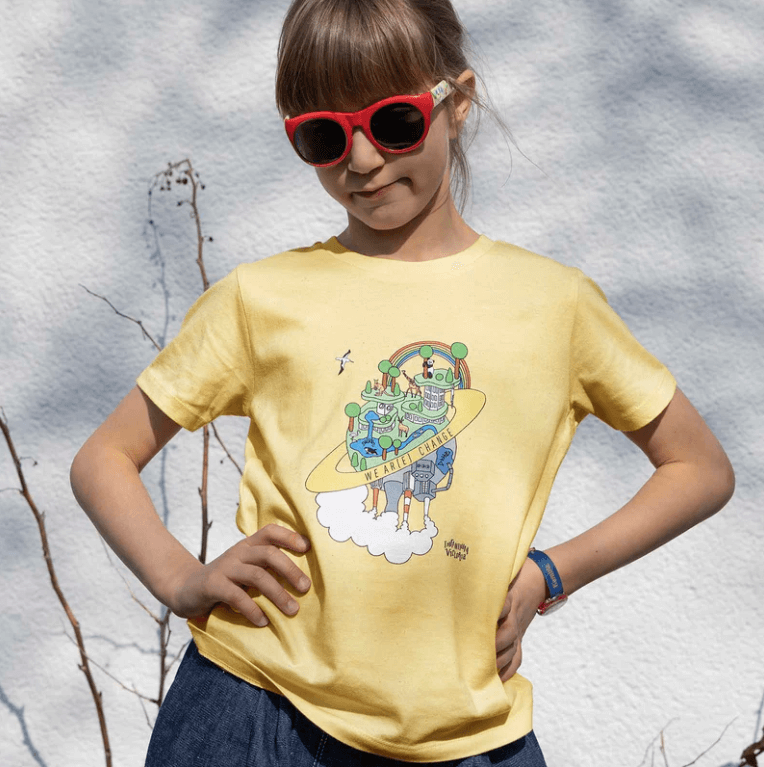 girl wearing a yellow Infantium Victoria tshirt with her hands on her hips and sunglasses on.